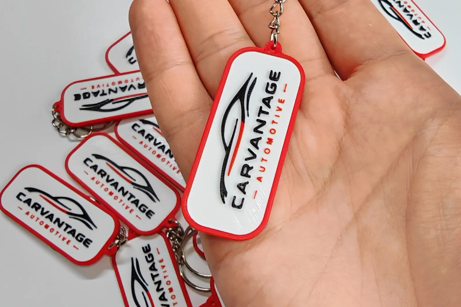 Smart brelok z logo Carvantage trzymany w dłoni, w tle pozostałe sztuki